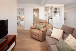 a living room with a couch and chairs and a television at Marineros Sureste A111 in Torre del Mar