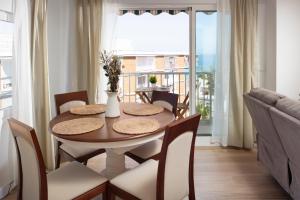 a dining room with a table and chairs and a balcony at Marineros Sureste A111 in Torre del Mar