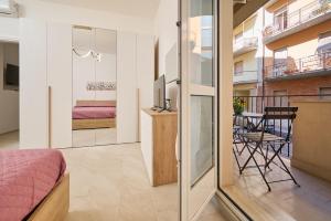 a bedroom with a bed and a tv and a balcony at Casa La Viola - Follonica in Follonica +25 photos