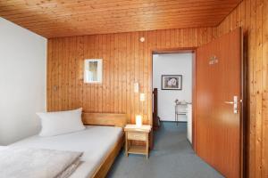a small bedroom with a bed and a wooden wall at Hotel Garni Siedlerstube in Nürtingen