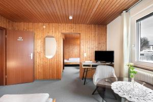 a living room with a table and a television at Hotel Garni Siedlerstube in Nürtingen +62 photos
