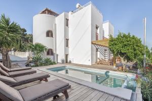 an exterior view of a house with a swimming pool at Villa Retreats in Santa Eularia des Riu