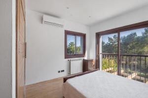 a bedroom with a bed and a balcony at Villa Retreats in Santa Eularia des Riu +36 photos