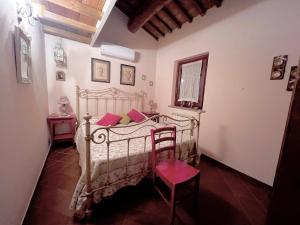 a bedroom with a white bed and a chair at Il Forcone in Panicale