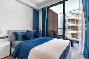 a bedroom with a bed and a large window at Sunshine by Villacarte in Layan Beach +126 photos