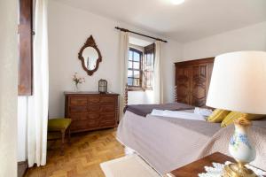 a bedroom with a bed and a table with a lamp at Casa do Adro do Soajo in Soajo