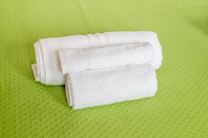 a stack of white towels on a green background at Helianthus in Cisternino +73 photos