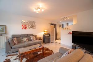 a living room with a couch and a tv at Appartement Atypique avec terrasse in Hyères