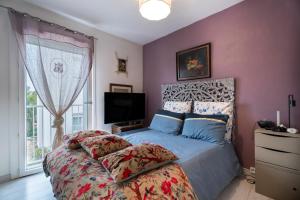 a bedroom with a bed and a tv and a window at Appartement Atypique avec terrasse in Hyères