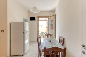 a kitchen with a table and a refrigerator at Rocco 1 in Torre San Giovanni Ugento