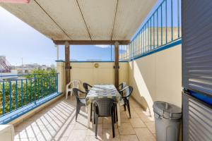 a patio with a table and chairs on a balcony at Rocco 1 in Torre San Giovanni Ugento