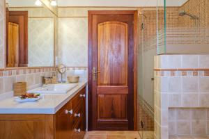 a bathroom with a sink and a wooden door at Casa Cristina Ibiza in Sant Carles de Peralta +17 photos