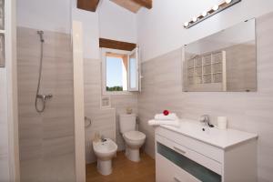 a white bathroom with a toilet and a sink at Can Ferrer in Alcudia +30 photos
