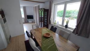 a dining room with a wooden table and a window at Ferienhaus Spes in Stockach