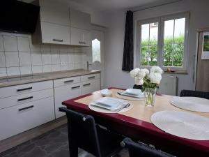 a kitchen with a table with a vase of flowers on it at Ferienhaus Spes in Stockach