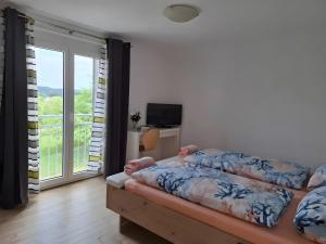 a bedroom with a bed and a sliding glass door at Ferienhaus Spes in Stockach