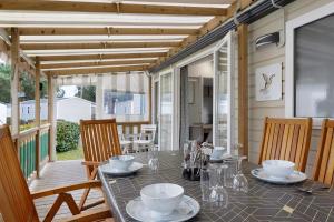 a table with plates and cups on a patio at Mobile Home du Bois Dormant in Saint-Jean-de-Monts