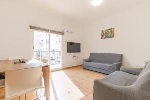 a living room with a couch and a tv at Entreplayas Benidorm in Benidorm