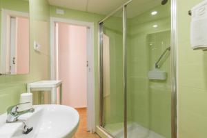 a bathroom with a sink and a glass shower at Entreplayas Benidorm in Benidorm +14 photos