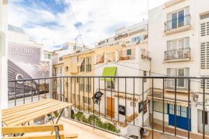 a balcony with a wooden bench in front of buildings at Entreplayas Benidorm in Benidorm