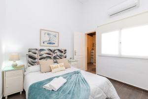 a white bedroom with a bed with a blue blanket at Fidalsa Relax Pool your Refuge in Torrevieja