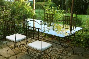 a table and chairs in a garden at Gite Les Trois Collines in Cuisiat