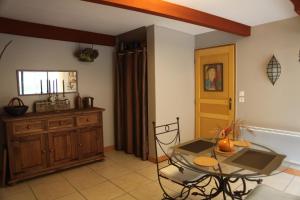 a living room with a glass table and a cabinet at Gite Les Trois Collines in Cuisiat