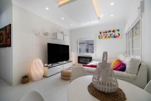 a living room with a couch and a tv at Casa Margara in Chipiona +19 photos
