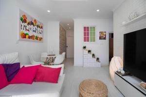 a living room with a white couch and a flat screen tv at Casa Margara in Chipiona