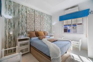 a bedroom with a bed with a blue comforter at Casa Margara in Chipiona