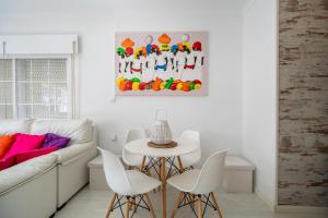 a living room with a couch and a table and chairs at Casa Margara in Chipiona