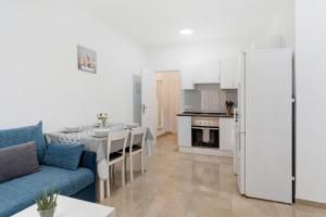 a living room with a blue couch and a kitchen at Un descanso 2 in San Fernando
