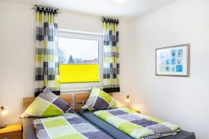 a bedroom with two beds and a window at Ferienwohnung Hilbers in Horumersiel