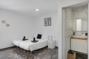 a white bedroom with a bed and a sink at Casa sofia in Arrecife