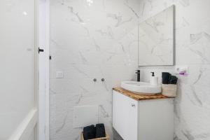 a white bathroom with a sink and a mirror at Casa sofia in Arrecife +36 photos
