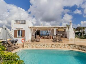 a villa with a swimming pool in front of a house at Villa Rocío in Binibeca