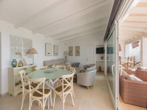 a kitchen and living room with a table and chairs at Villa Rocío in Binibeca