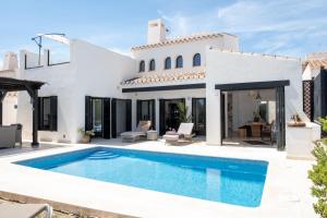 a villa with a swimming pool in front of a house at Casa Trebol - Private Pool Villa in San Javier