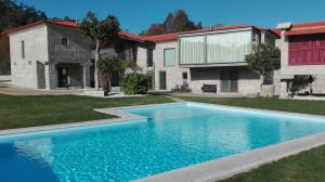 a swimming pool in front of a house at Casa do Sobreira in Vieira do Minho
