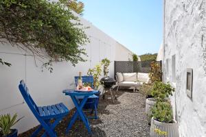 a small patio with blue chairs and a table at El Piccolo in Mácher