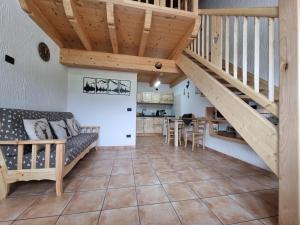 a living room with a staircase and a table at Appartamento Adamello 5 in Pinzolo