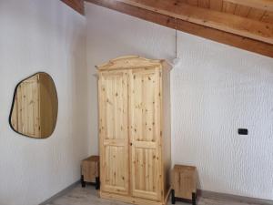 a wooden cabinet in a room with a mirror at Appartamento Adamello 5 in Pinzolo