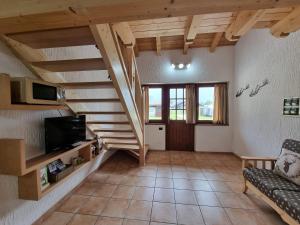 a living room with a staircase and a couch at Appartamento Adamello 5 in Pinzolo
