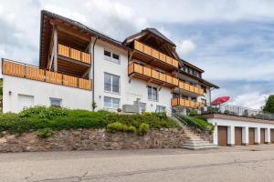 a large white building with a balcony on top of it at Hochtalblick - Fewo Oren in Bernau im Schwarzwald