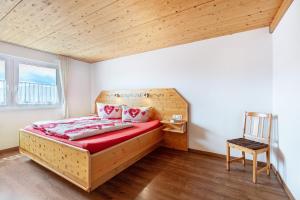 a bedroom with a bed and a chair in it at Hochtalblick - Fewo Oren in Bernau im Schwarzwald