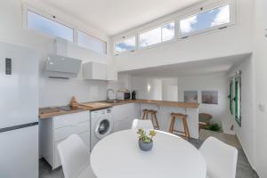 a kitchen and dining room with a white table and chairs at Apartamentos Callao in Playa Quemada