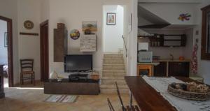 a living room with a television and a staircase at Villetta Vittoria in Macari