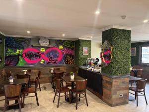 a restaurant with tables and chairs and graffiti on the walls at Infinity Park Hotel in Santiago