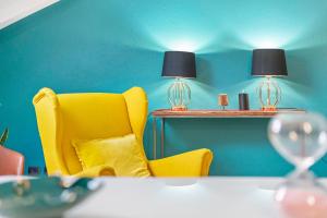 a yellow chair sitting next to a table with two lamps at Mema Holiday Home in Aosta