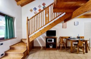 a staircase in a room with a desk and a computer at Appartamento Adamello 9 in Pinzolo